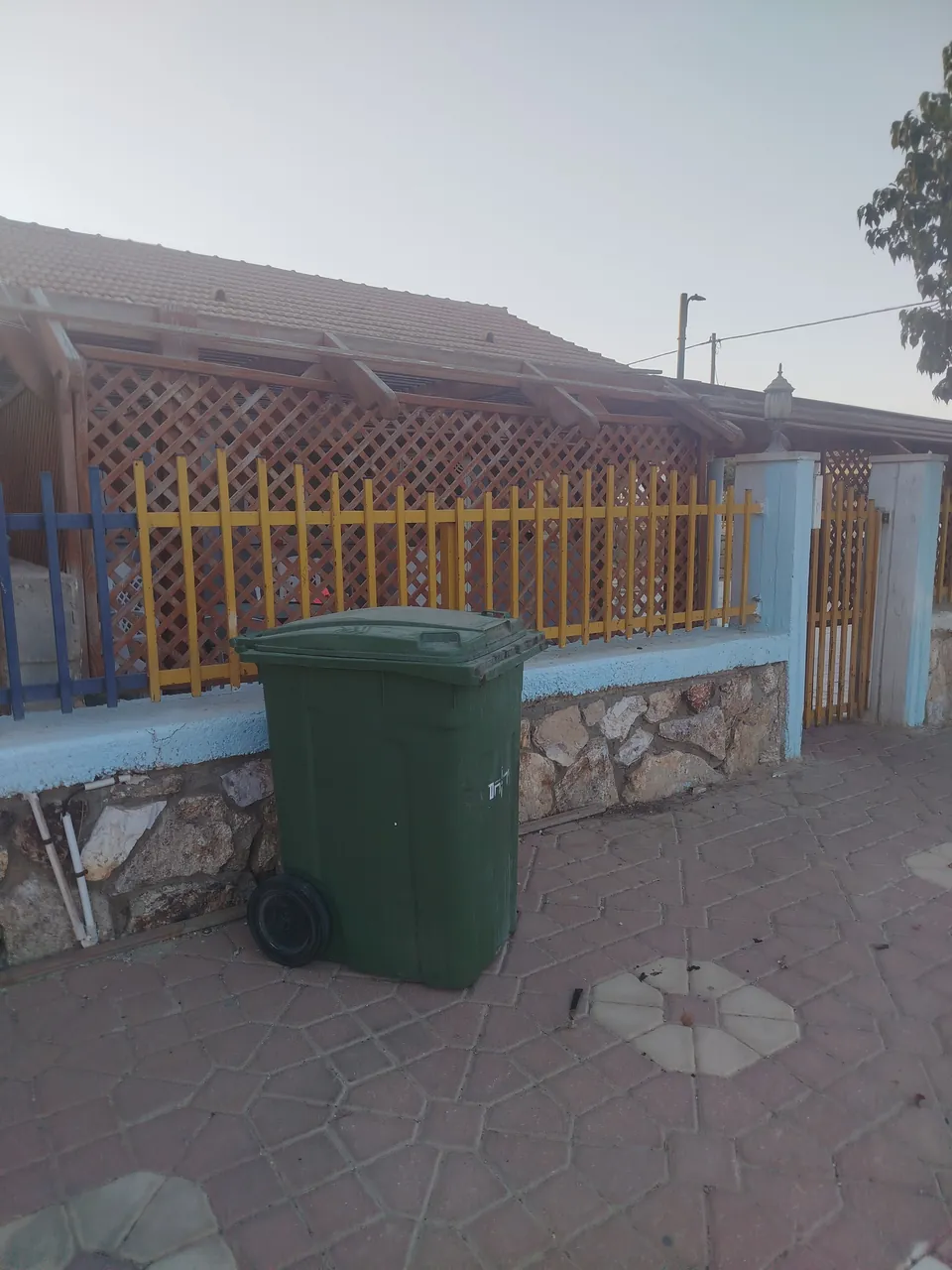 פח אשפה שלא מוחזר למקומו ומקשה על אישה מבוגרת — לפני